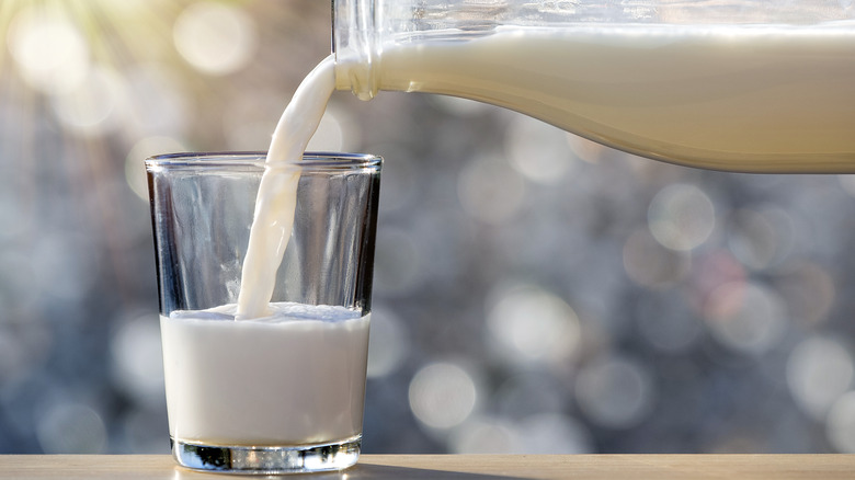 pouring milk from bottle to glass