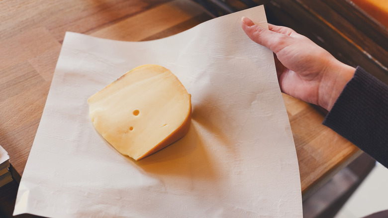 hand wrapping cheese in paper