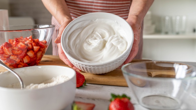 Person making whipped dessert with strawberries