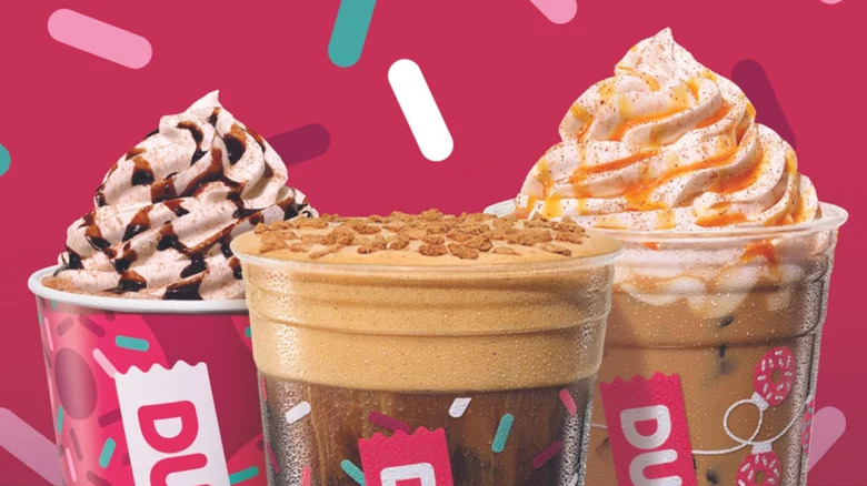 Three Dunkin' holiday lattes on pink background