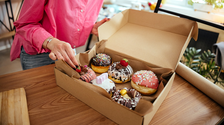 Person opening a box of donuts