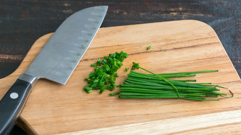 minced chives knife wooden board