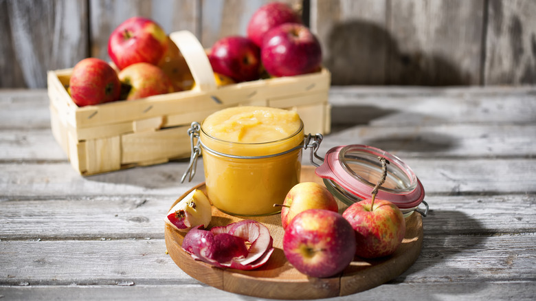 Fresh apples with jar of applesauce