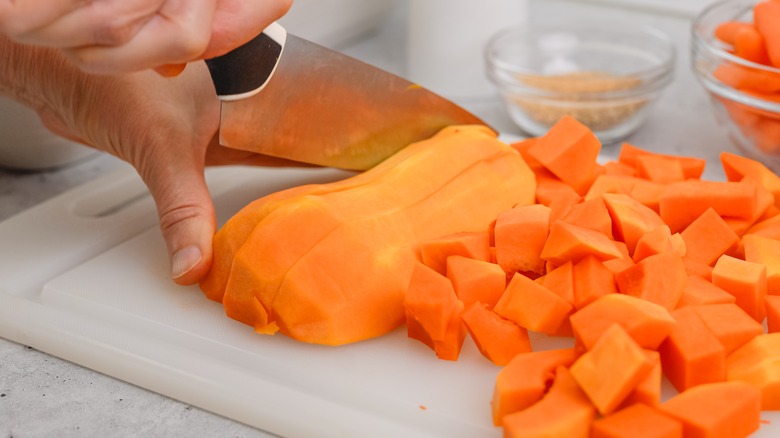 chopping butternut squash on cutting board