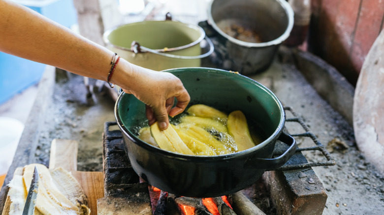 Plantains boiling in a pot of water over an open fire