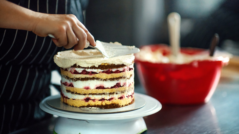 putting icing on layer cake