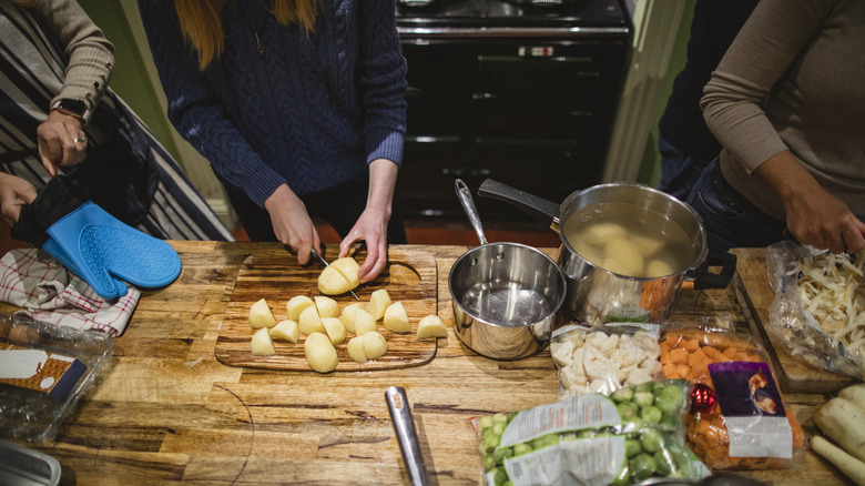 People gathered slicing vegetables