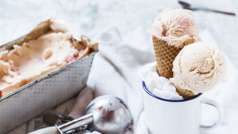 pan of homemade ice cream and scooped cones sitting in a coffee mug