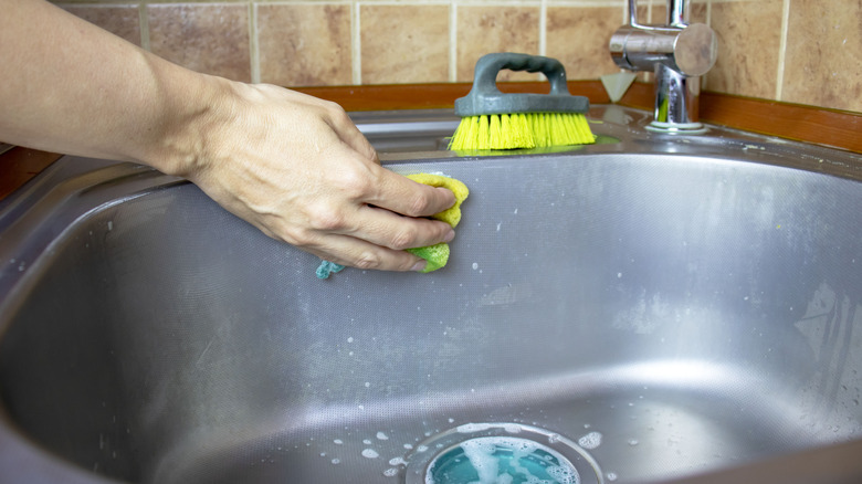Hand cleaning soap scum from a sink