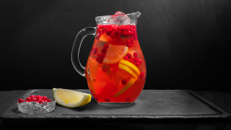 Pitcher of cranberry cocktail with lemons