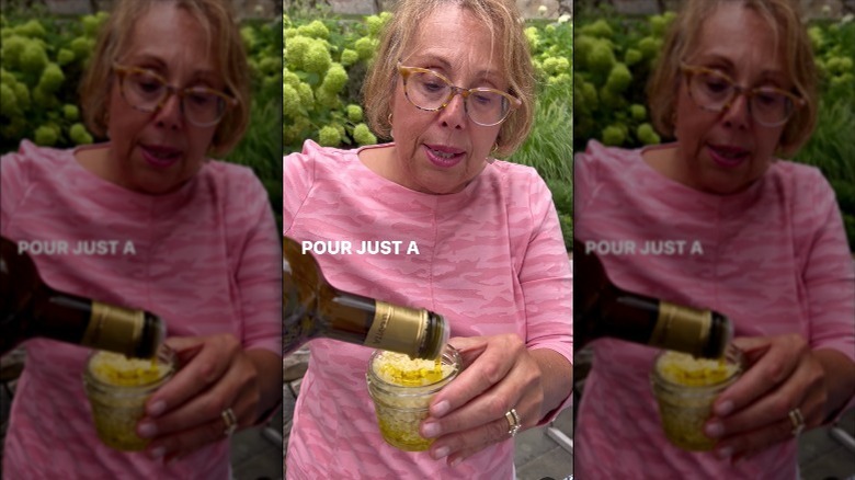 Babs' pours oil into jar of garlic