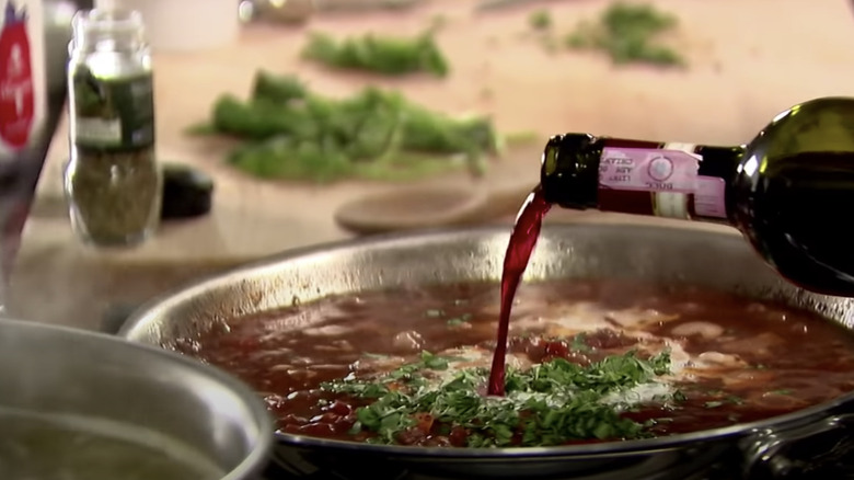 pouring red wine into a sauce