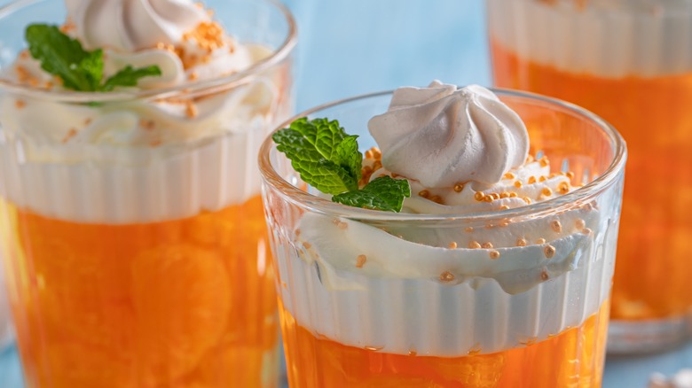 orange jello with whipped cream and fruit