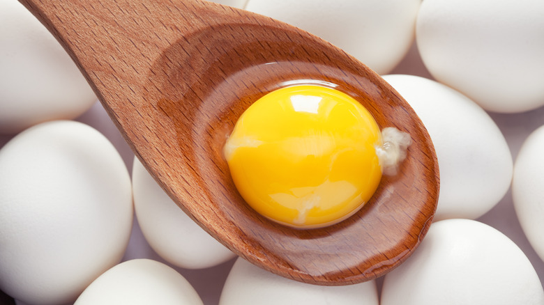 egg yolk on wooden spoon