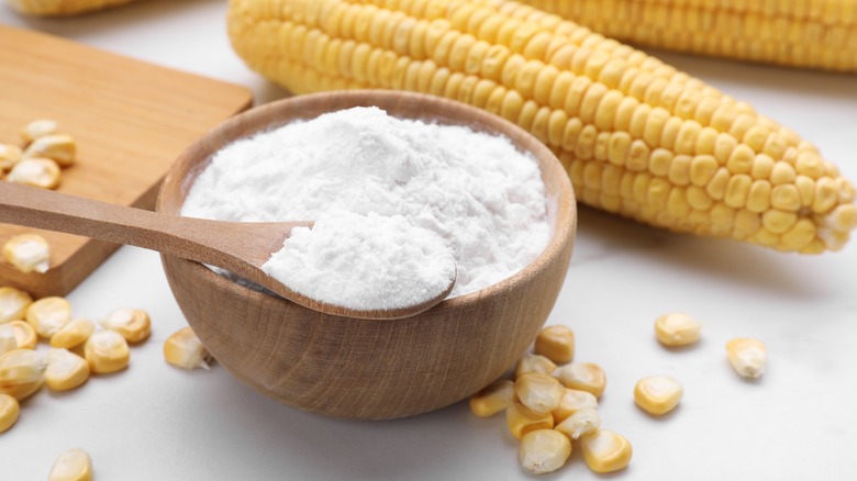 Bowl of cornstarch beside corn on the cob