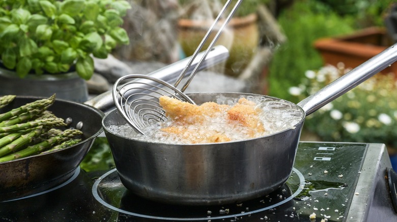 spider tool lifting fried food from oil