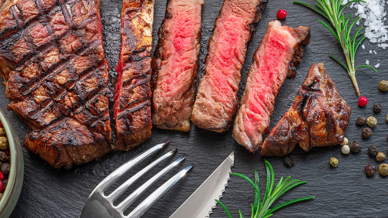 Sliced steak, a fork, and a knife