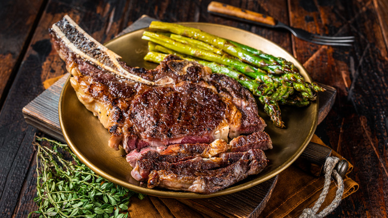 Bone-in steak, wine glasses, and wine bottles