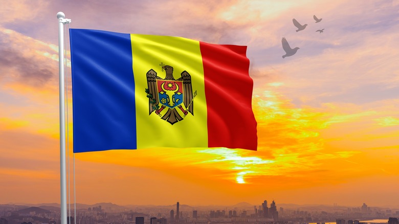 Moldovan flag above city at sunset