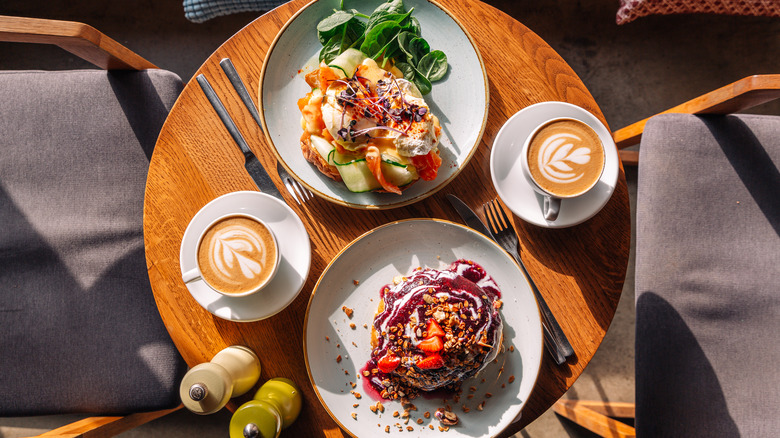 Cafe table with coffee, salad, and cinnamon roll