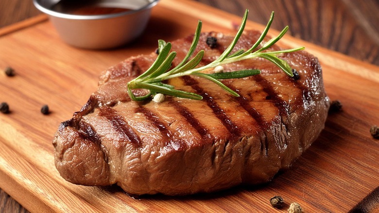 grilled steak on a thick wooden cutting board