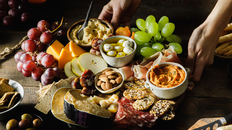 hands serving charcuterie board