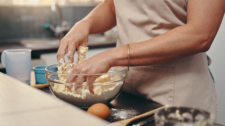 baker mixing dough by hand