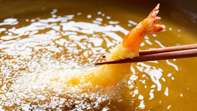 Shrimp being placed in frying oil