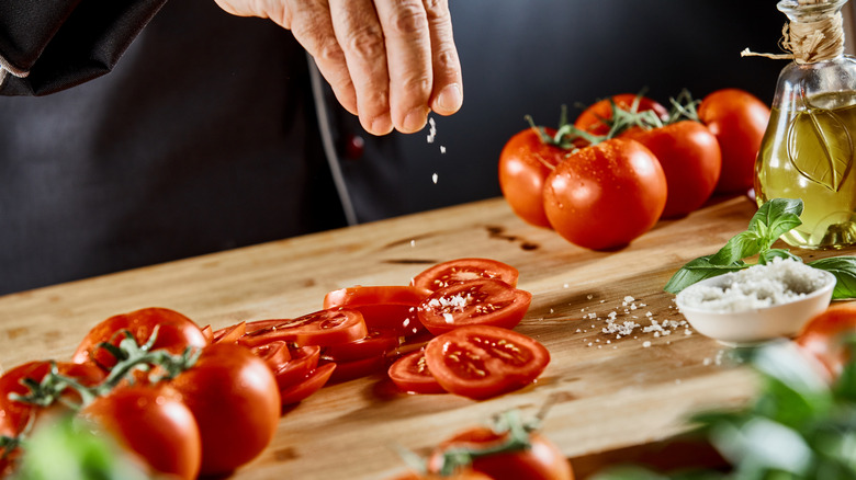 Sprinkling salt on tomato