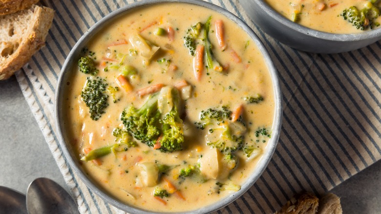 A bowl of homemade broccoli cheddar soup on cloth