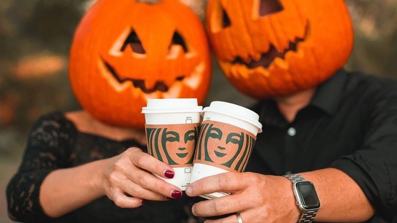 People wearing pumpkin heads with Starbucks