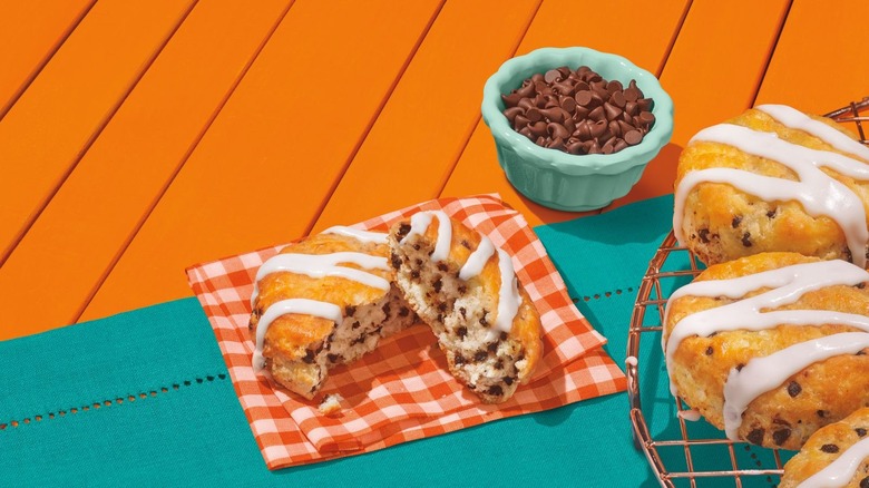 Popeye's chocolate chip biscuit cut in half on orange table