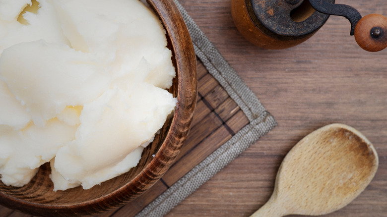 tallow in wooden bowl beside wooden spoon