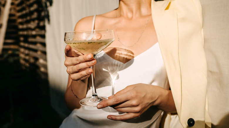 A woman holding a cocktail glass