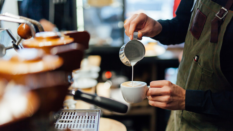 female barista making latte art