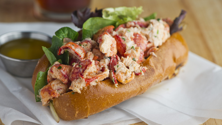 lobster roll on wax paper with a ramekin of drawn butter
