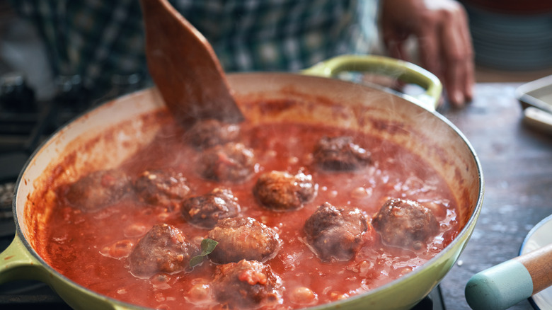 Cooking meatballs with sauce in pan