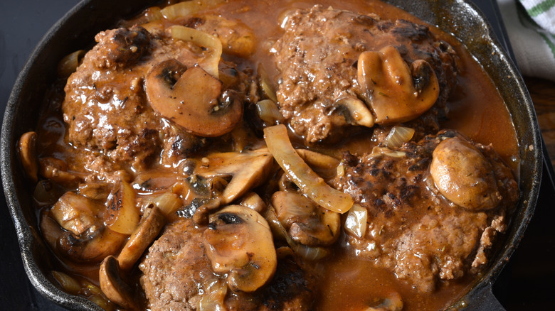 Hamburger steaks cooking in pan