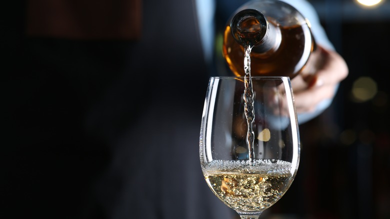 Bartender pouring glass of white wine