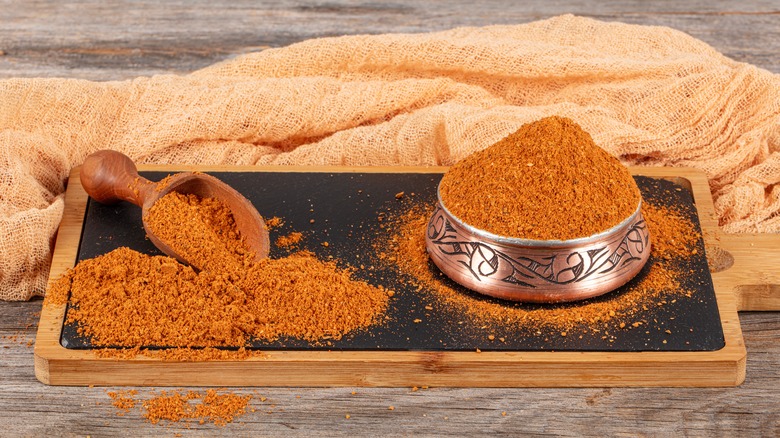 Ground dehydrated kimchi in a bowl and spoon on a tray