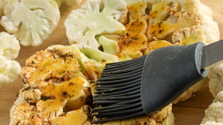 brushing seasoning over cauliflower steak