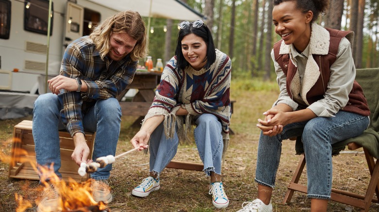 young people roasting marshmallows