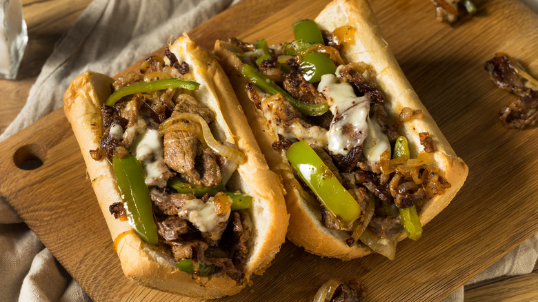 Two Italian beef sandwiches on hoagie with cheese and green peppers