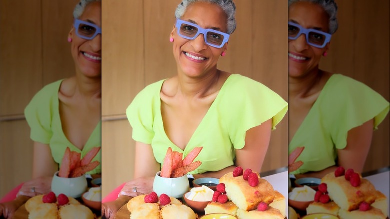 Carla Hall smiling with plate of food