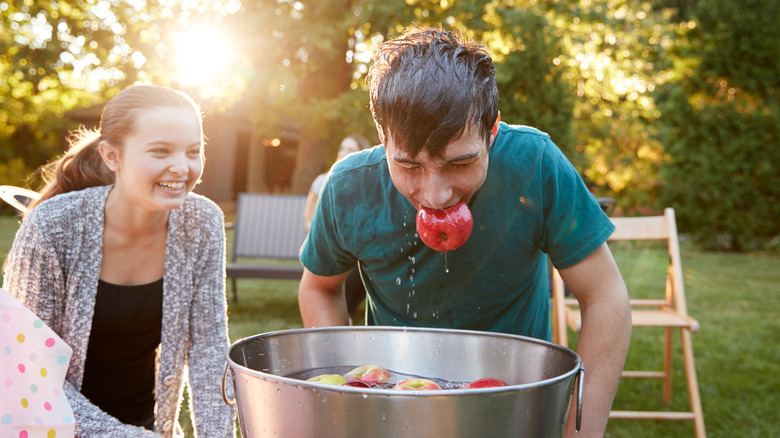 Bobbing for apples at party