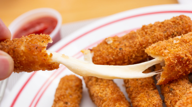 Mozzarella stick being pulled apart