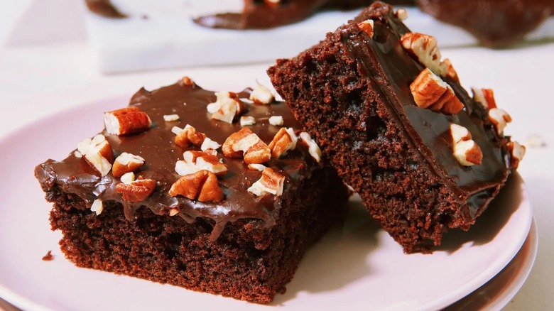 Cut chocolate sheet cake with nuts