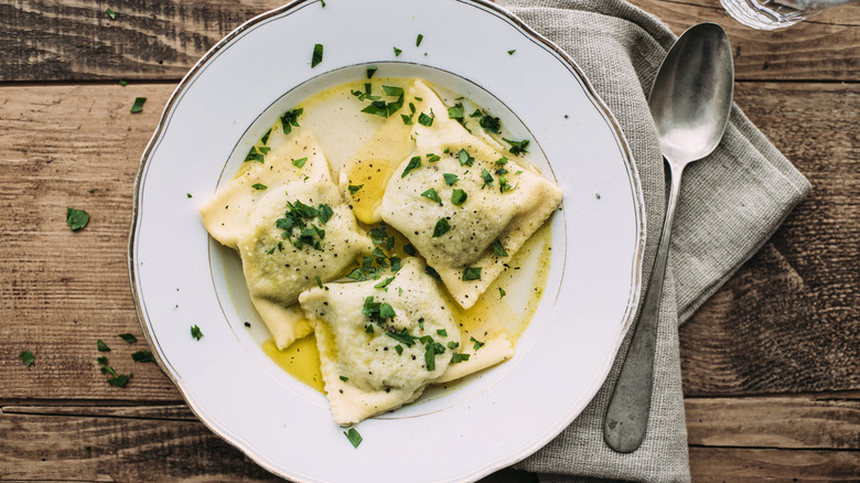 Thick ravioli with oil and herbs