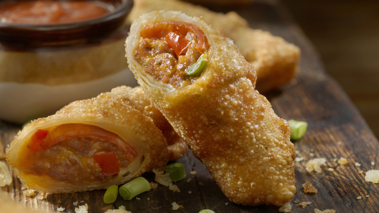 fried pizza snack rolls on a wood cutting board