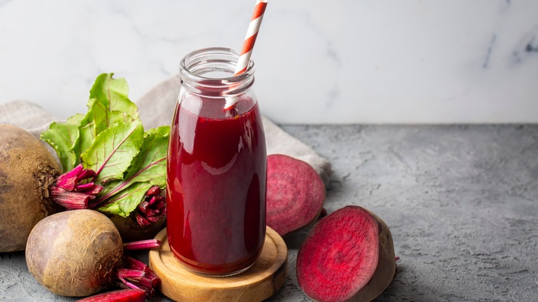 fresh beet juice in glass with beets nearby